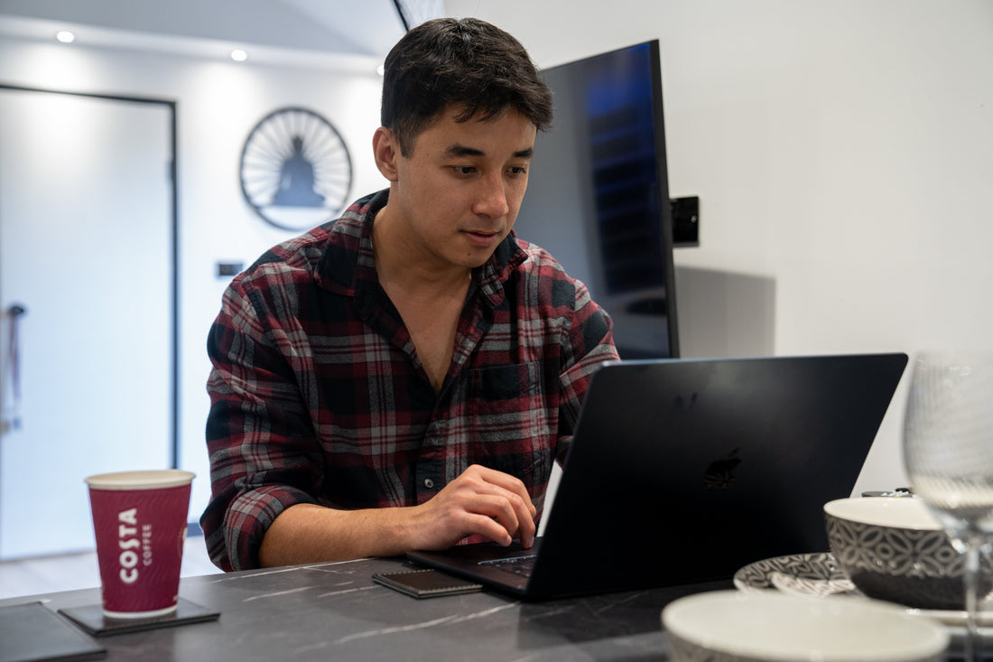 Adhish, founder of Stoic Note, writing the first Making the Brand blog post on his laptop